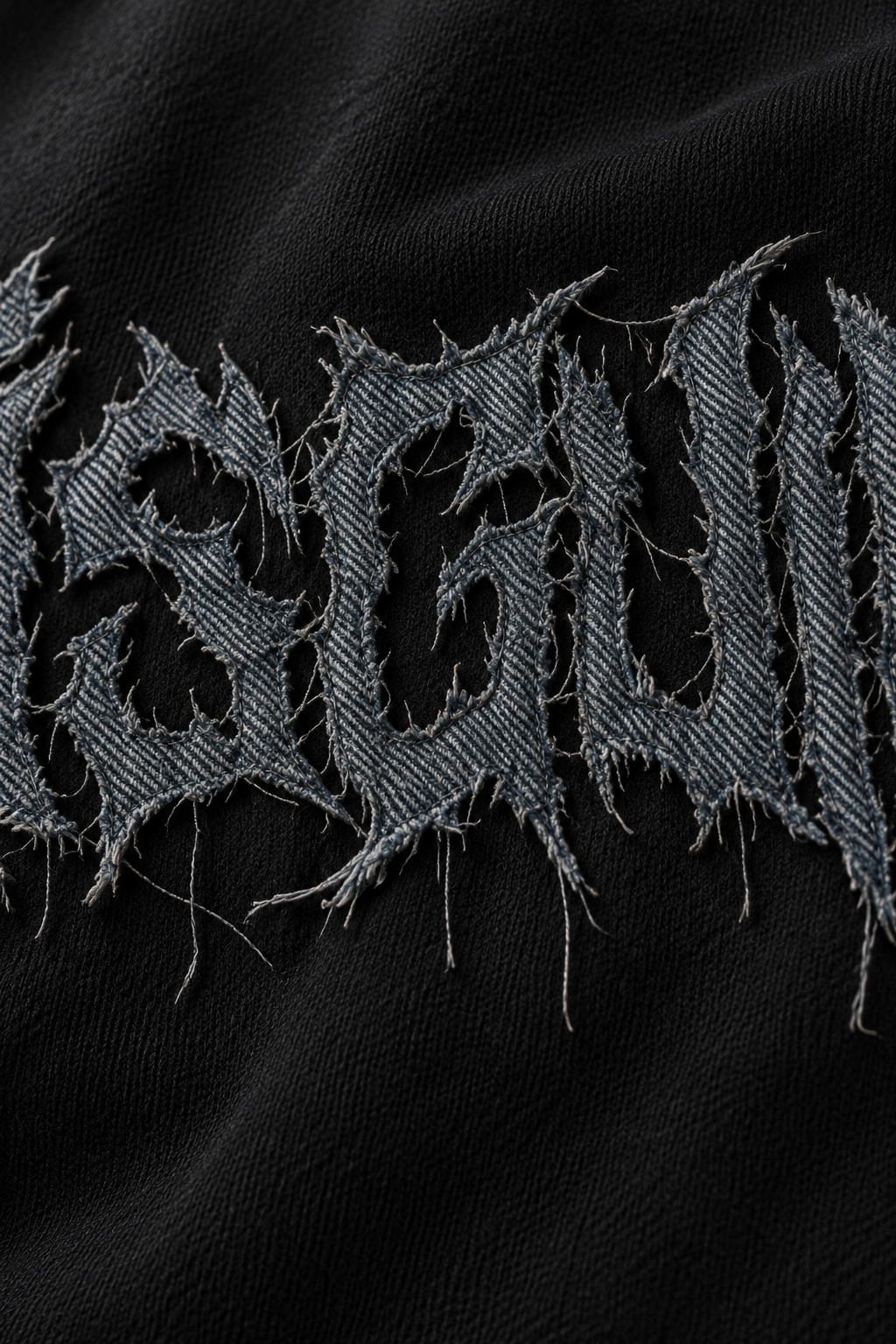 Charcoal distressed denim logo close-up